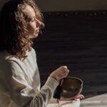 Persona meditando en un ambiente interior de luz natural y calma